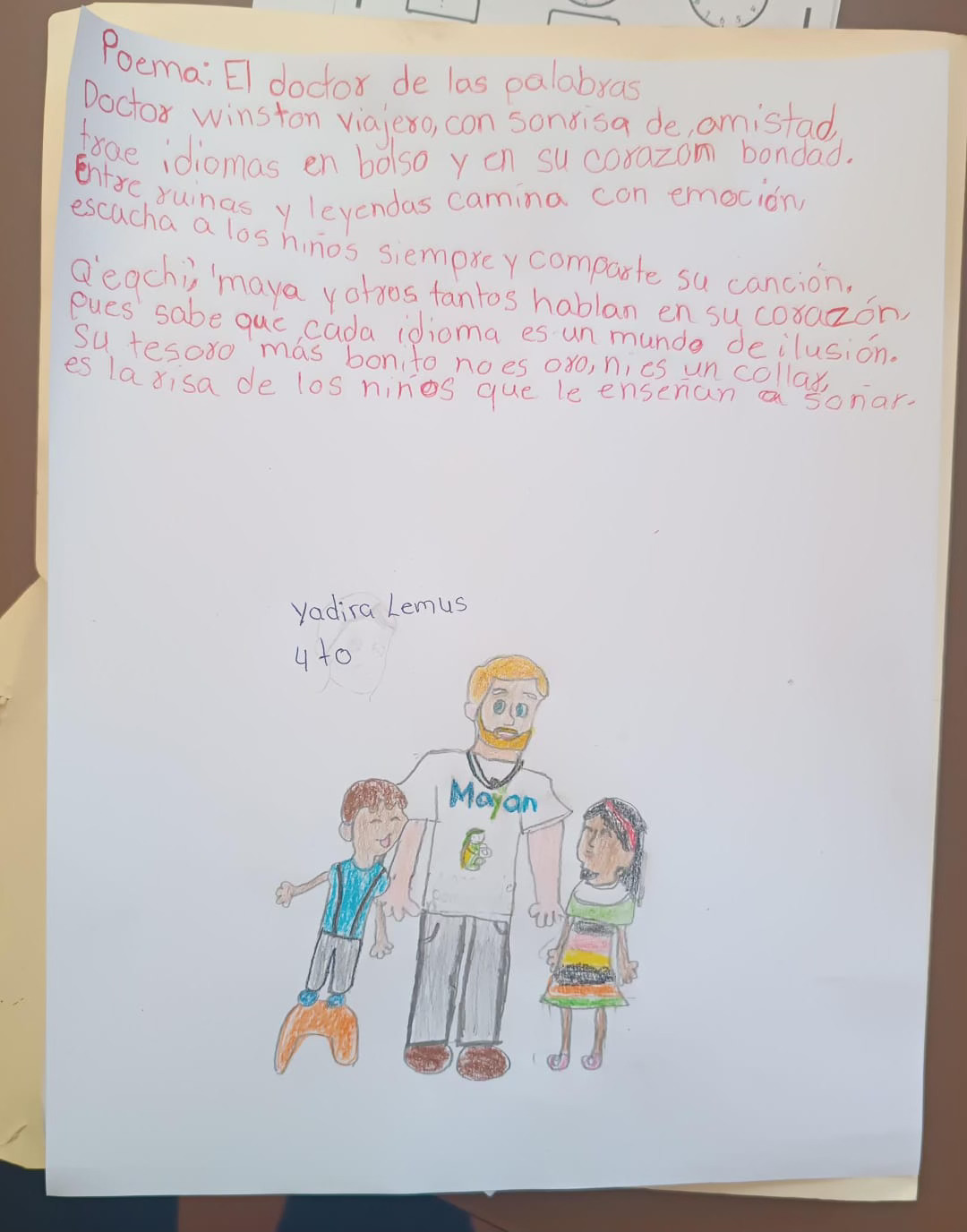 A picture drawn in crayon with a poem at the top and a drawing of the Director of the Mayan Language Preservation Project with two children to the left and right.